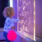 petite fille jouant avec un mur un eau, ballon rebondissant, bulles, salle d'apaisement