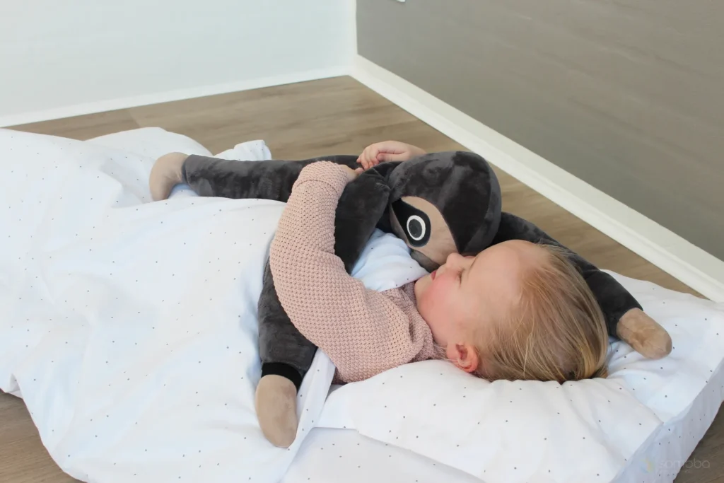 petite fille, sieste, peluche paresseux lestée